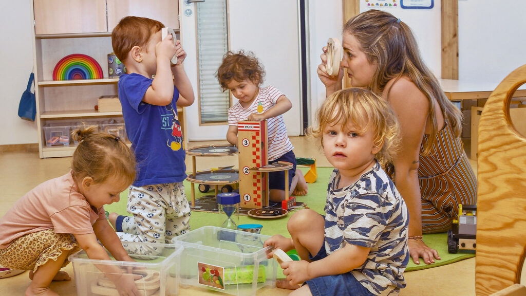 Die Kinder der SGA Sport-Kita spielen gemeinsam mit einer Betreuerin.