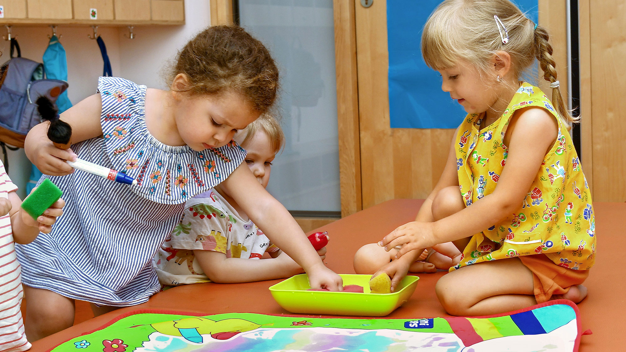 Die Kinder der SGA Sport-Kita malen zusammen mit Wasserfarben.