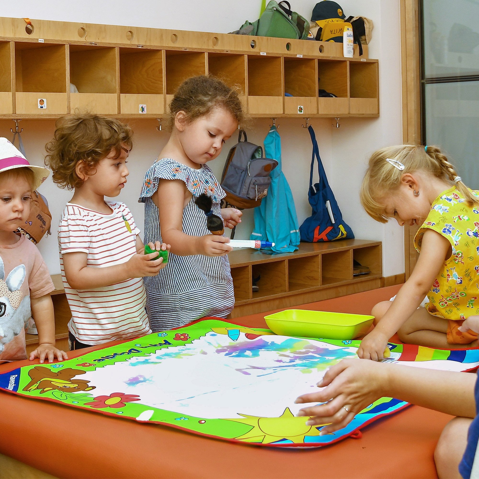 Die Kinder der SGA Sport-Kita malen zusammen mit Wasserfarben.