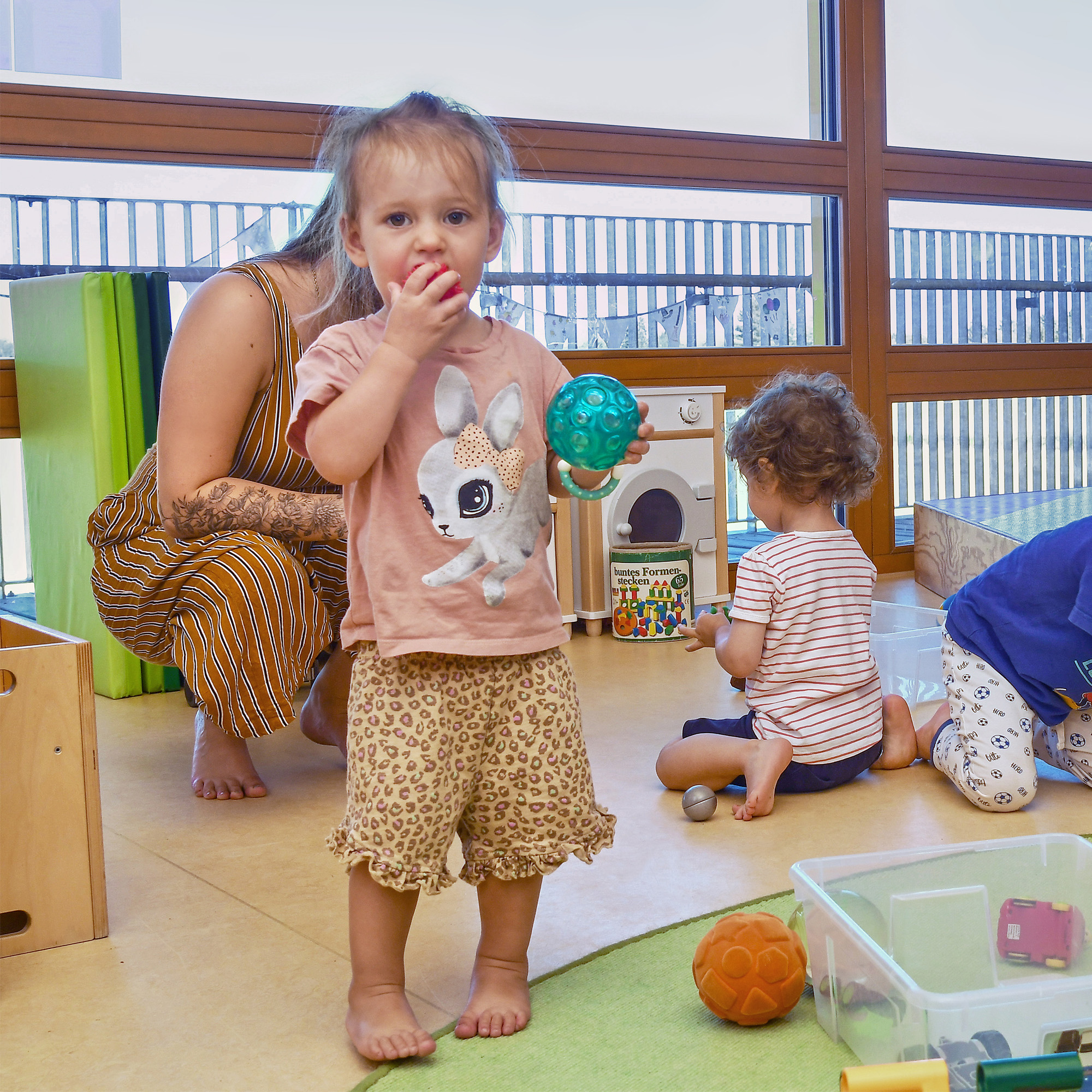 Die Kinder der SGA Sport-Kita spielen gemeinsam mit einer Betreuerin.